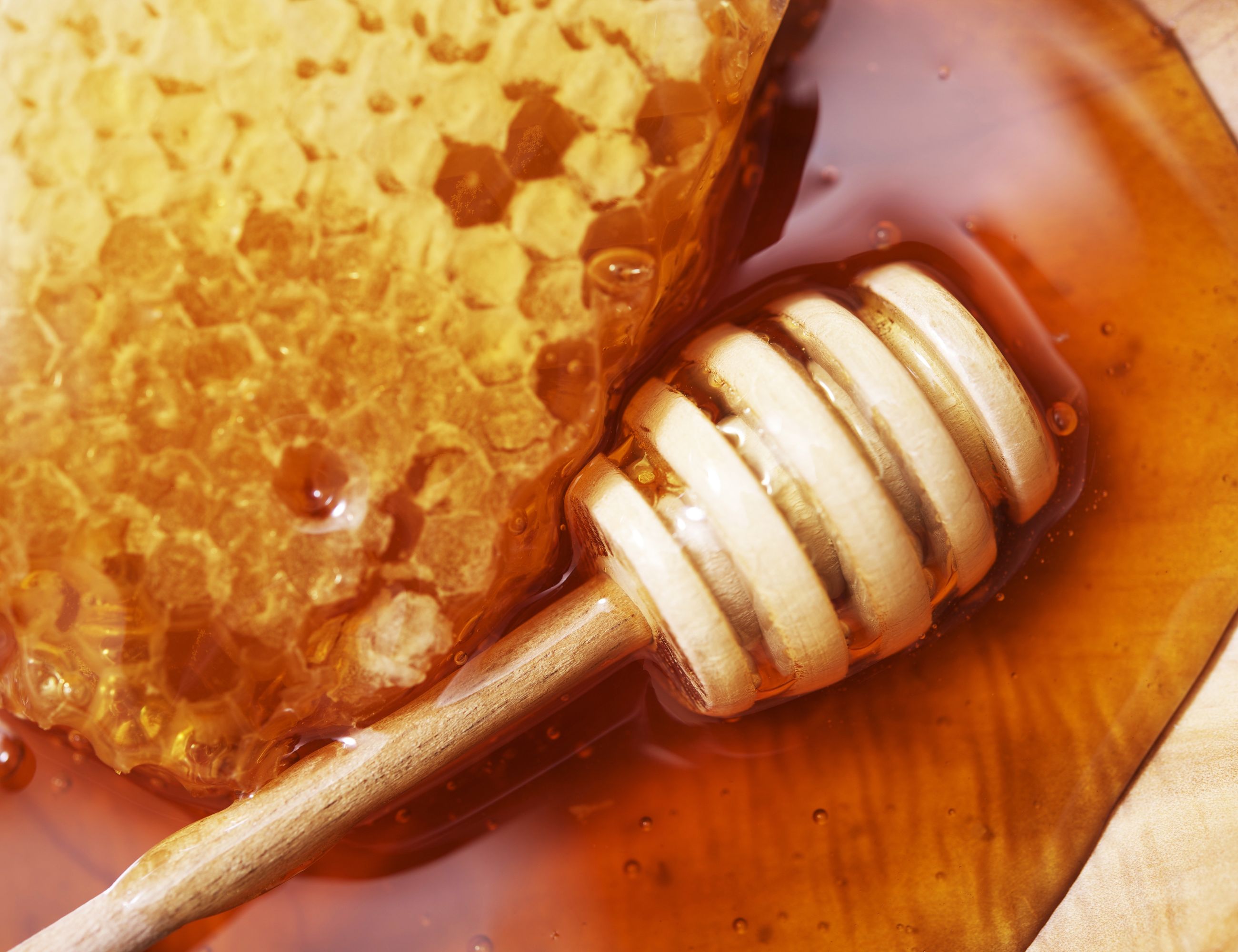 comb honey with a stick stir