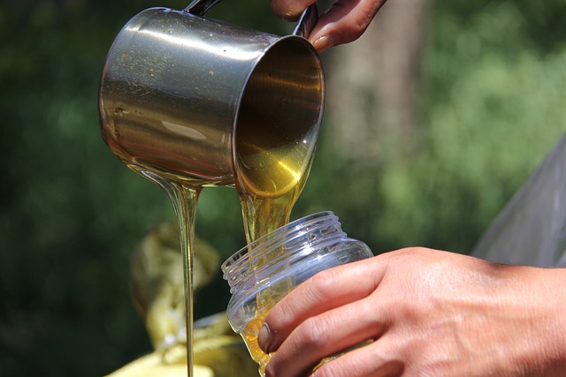 pouring honey into jar