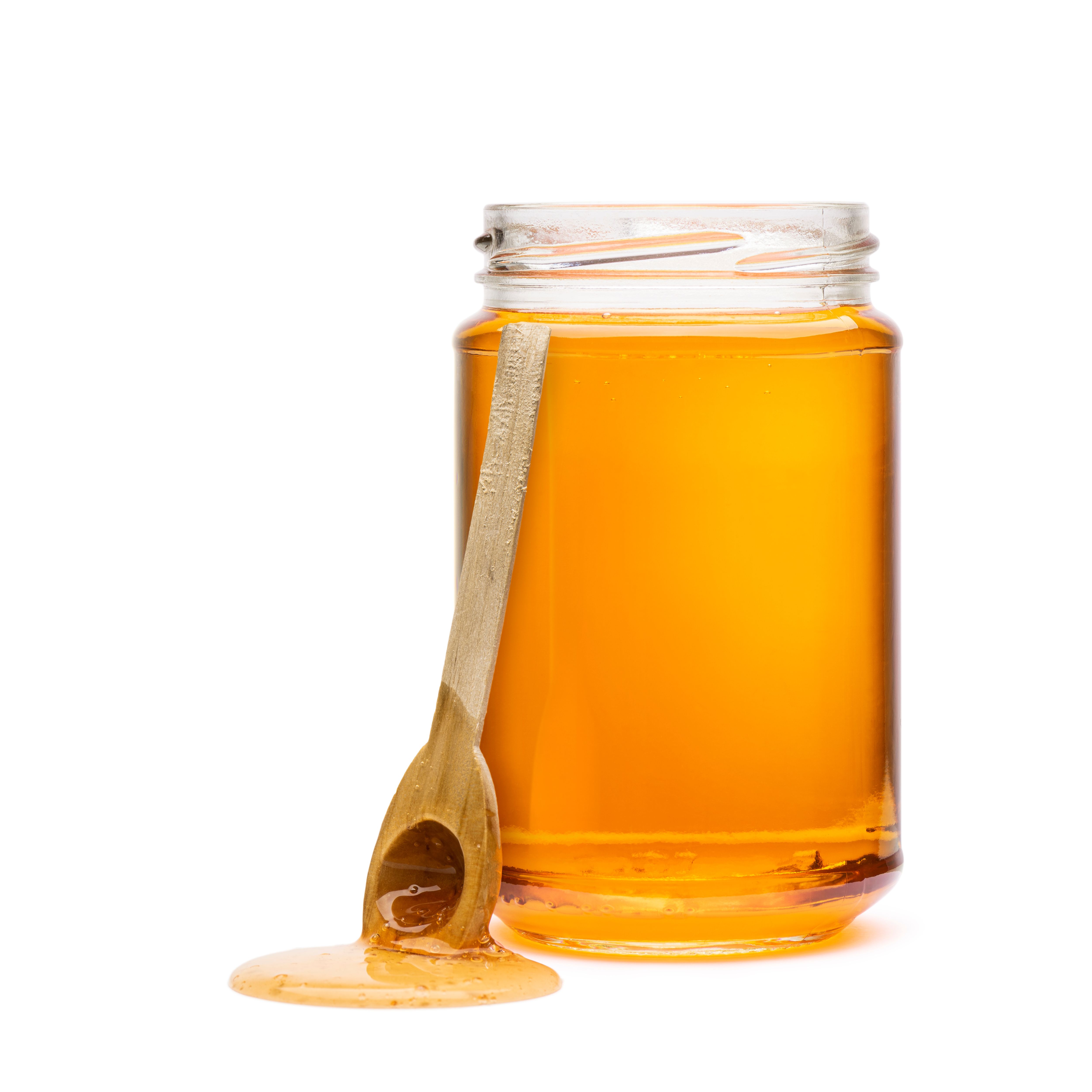 honey in a jar with a handmade wooden spoon