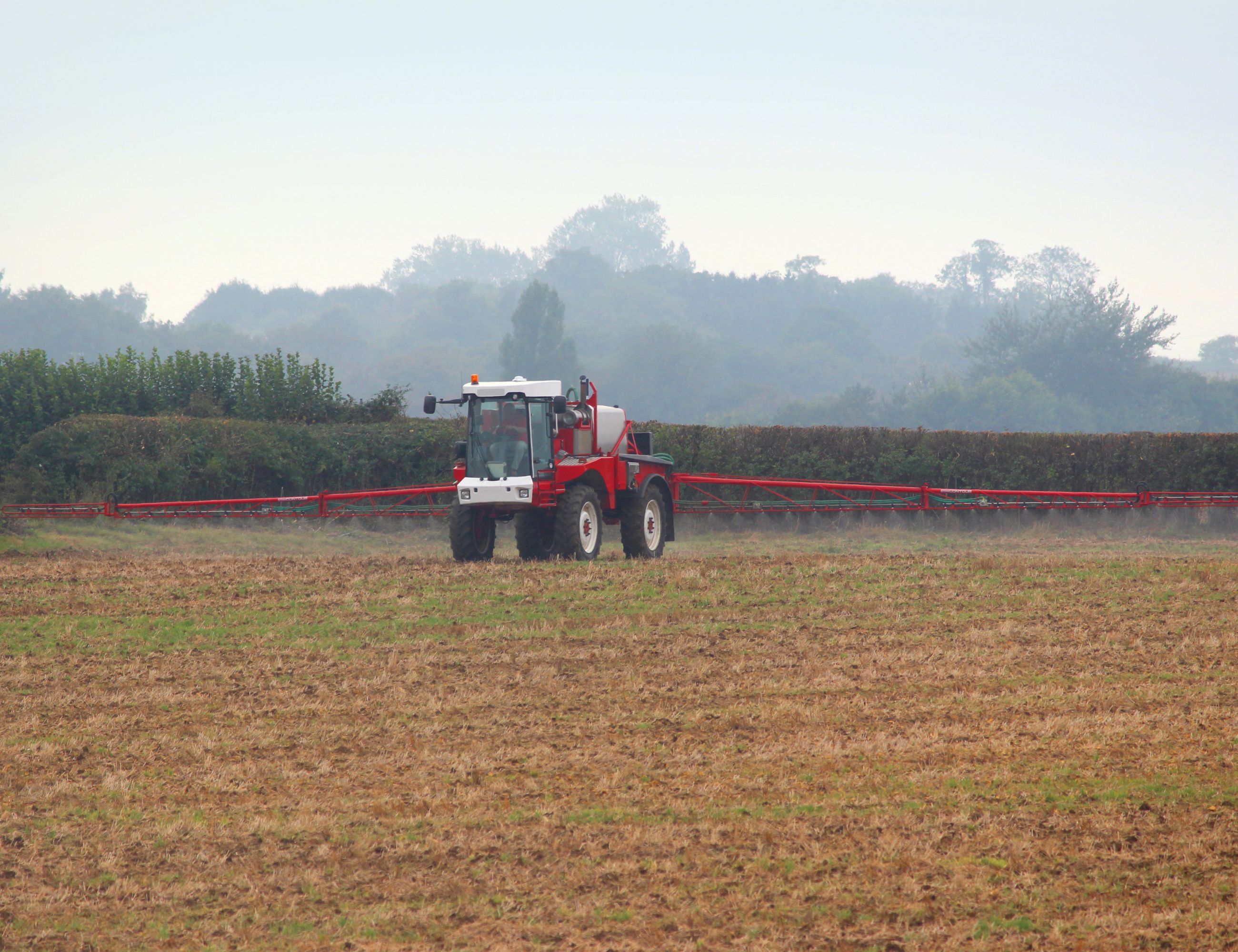 Tractor spraying a field with pesticides