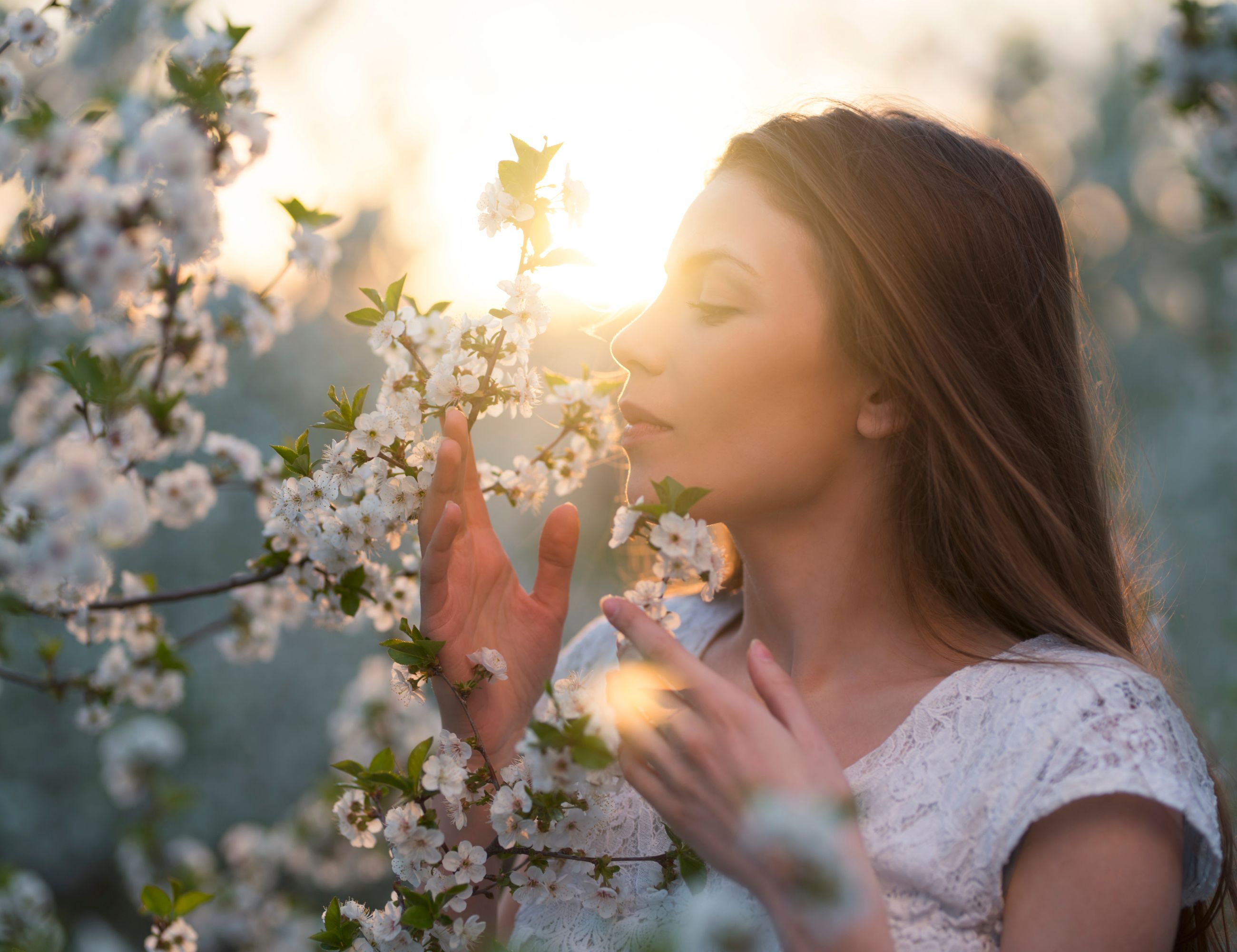 woman smelling an apple blossom